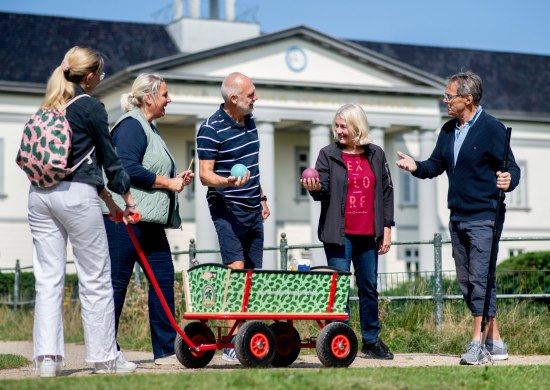 Gruppe mit Boßelkugeln und Bollerwagen bei einer Stadtführung zum Thema Grünkohl in Oldenburg