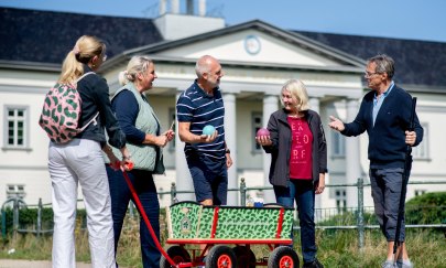 Gruppe mit Boßelkugeln und Bollerwagen bei einer Stadtführung zum Thema Grünkohl in Oldenburg