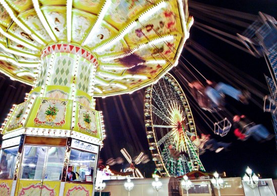 Nachtaufnahme mit beleuchtetem Kettenkarussell und Riesenrad auf dem Oldenburger Kramermarkt.